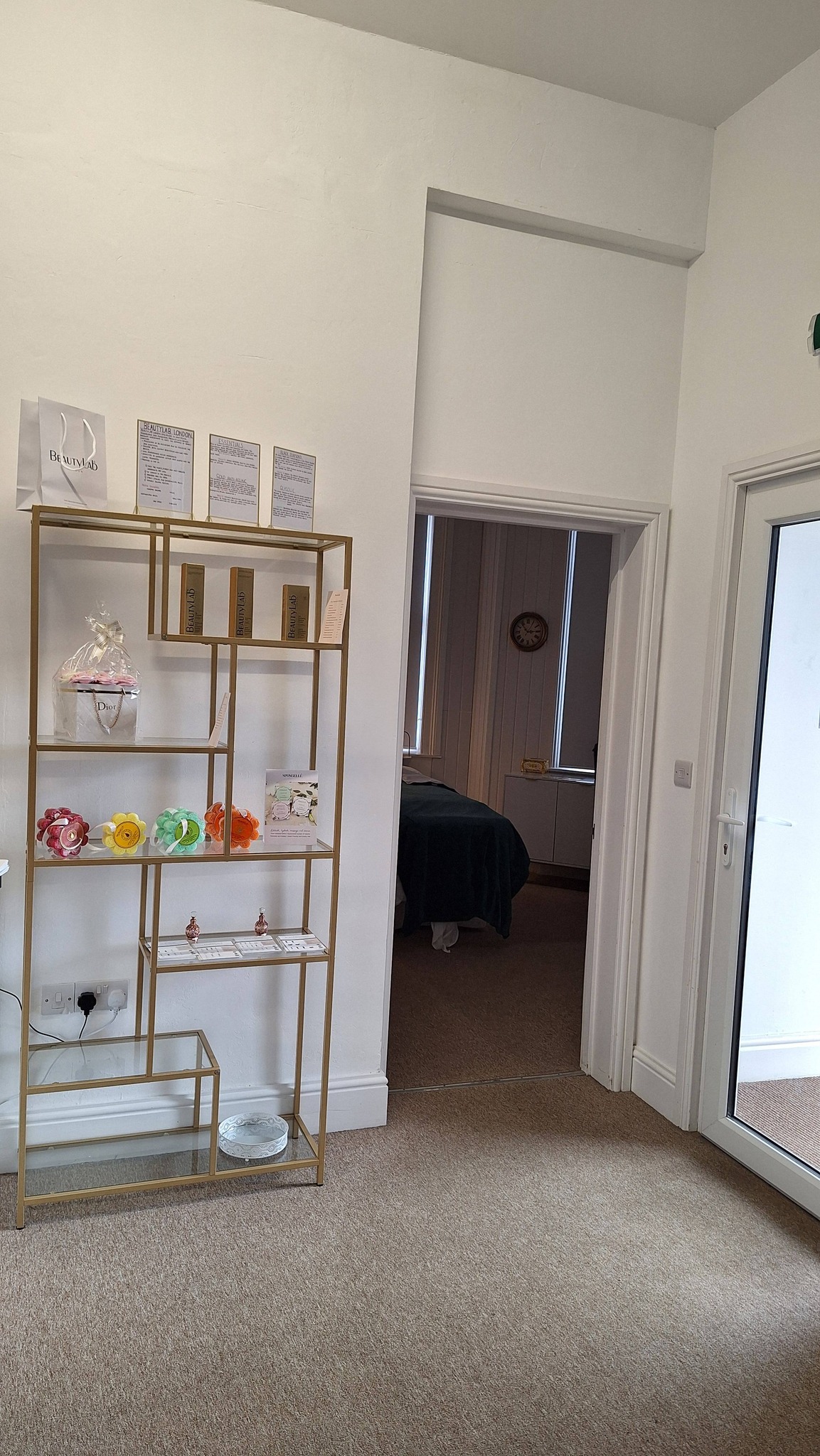 Gold ladder shelving displaying BeautyLab London skincare products and certificates.